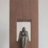 Zittende vrouw (keramiek) in houten zuil