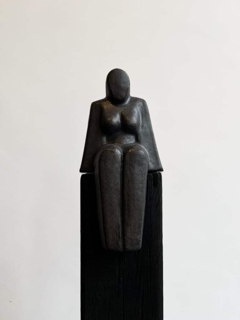 Zittende vrouw op Zwarte Zuil